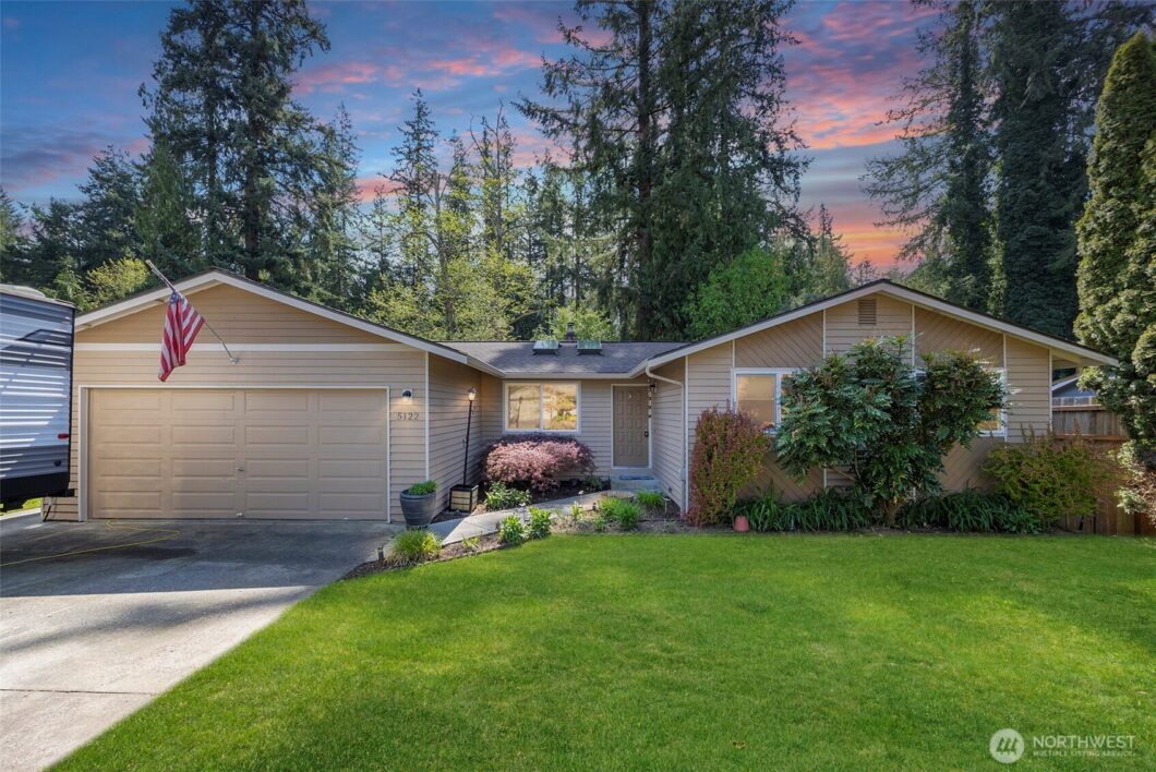 Tucked in the heart of Marysville, this charming rambler sits on nearly a quarter acre and backs up to a lush greenbelt, offering privacy and peaceful views. Step inside to find fresh interior paint and a versatile kitchen with moderately updated countertops, flowing seamlessly into the dining and living areas - perfect for both daily living and entertaining. Just off the living space, a spacious **entertaining deck** awaits, surrounded by greenery and ideal for relaxing or hosting under the trees. The expansive yard offers room to roam, and the front driveway includes RV parking for your extra toys. The home is also wired for a hot tub, just bring your vision. A rare blend of comfort, space, and location, don’t miss this one! 5122 130th Place NE Marysville Washington | The Madrona Group